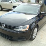 Before and after photographs of a damaged black Volkswagon Jetta that was repaired by Elite Paint & Body Shop in West Palm Beach, Florida.