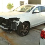 Before and after photographs of a damaged white, AUDI Quattro SUV that was repaired by Elite Paint & Body Shop in West Palm Beach, Florida.