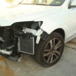 Before and after photographs of a damaged white, AUDI Quattro SUV that was repaired by Elite Paint & Body Shop in West Palm Beach, Florida.