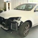 Before and after photographs of a damaged white, AUDI Quattro SUV that was repaired by Elite Paint & Body Shop in West Palm Beach, Florida.